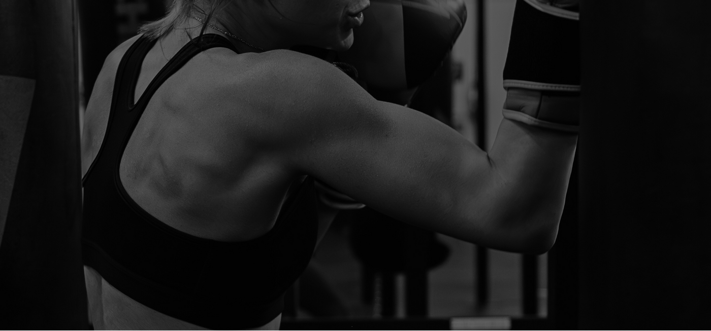 Person wearing boxing gloves in a gym setting